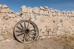Wagon wheel and remnants of an old wall