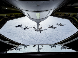 A-10 Thunderbolt II aircraft fly in formation behind a KC-135 St