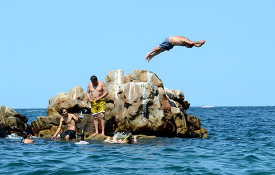 man jumps of the rocks along cabo san lucas