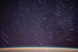 streaks of a starry field above earth