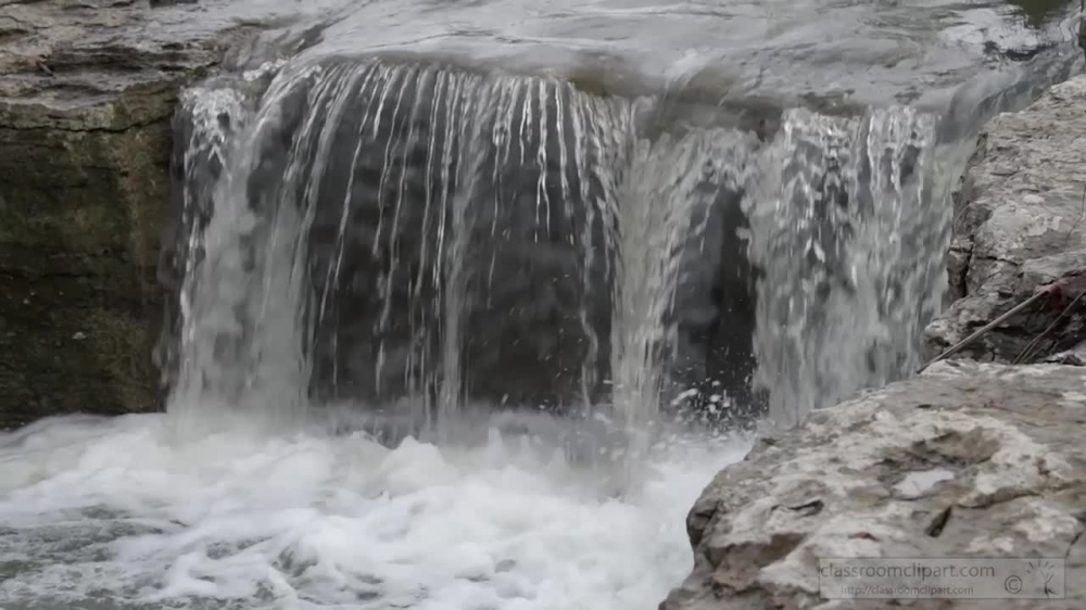 slow motion video of rain flowing off rocks