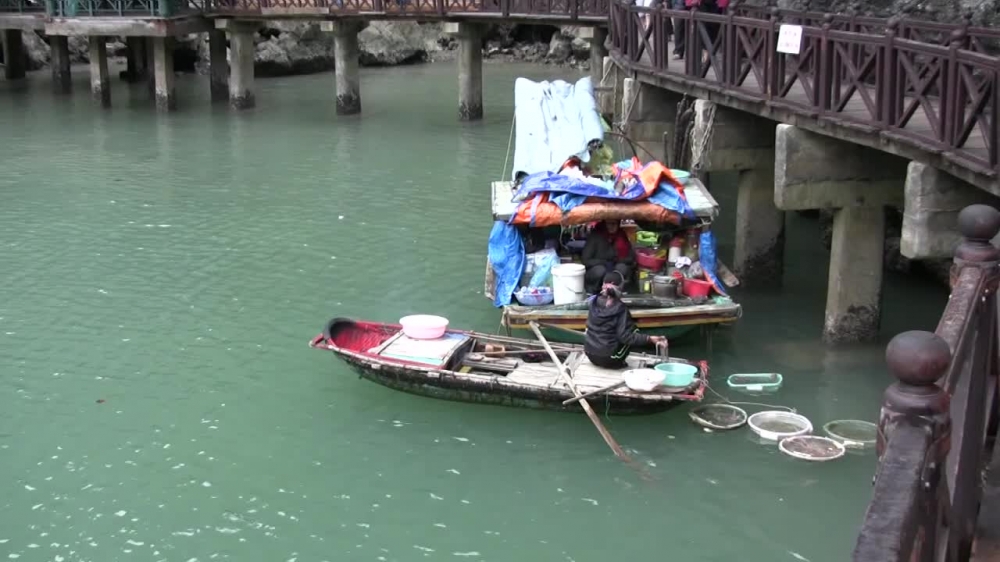 women in boats selling fish halong bay