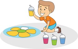 boy sitting on floor creating artwork using many colors clipart