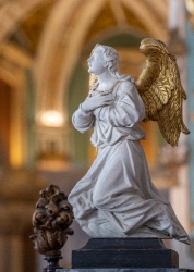 angel with folded hands over heart
