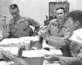 Apollo 7 astronauts  compare notes at a mission debriefing