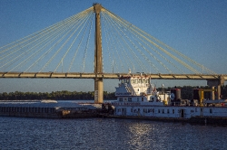barge traveling on mississippi river near cable stayed bridge