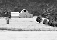 black and white farm scene covered in snow