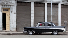 black vintage car sits on a street in Old Havana