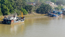 boats docked along river banks Myanmar