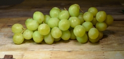 Bunch of fresh sweet green grapes on wood background photo