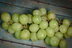 Bunch of vitamin filled green grapes on wood background