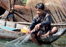 Child Fishing in Water Floating Village of Chong Khneas