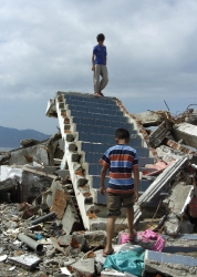 children on the remains of their home after tsunami