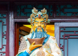 colorful statue of chinese man in gardents