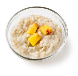 cooked oatmeal topped with three peaches