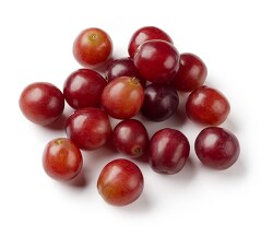 cup whole red grapes on white background