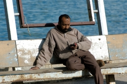 egyptian man sitting at harbor near citadel alexandria egypt 528