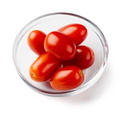 grop of red cherry tomatoes in bowl on white background