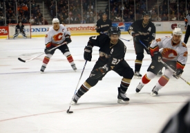 ice hockey players chasing puck