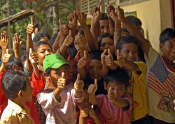 Indonesian children give a thumbs-up in for relief aid
