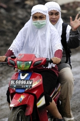 Indonesian Women on a motorcycle ride back from their home that 
