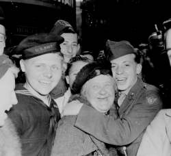 Jubilant American soldier hugs motherly English woman