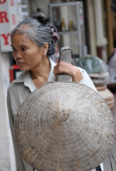 Lady carries items for sale in hanoi
