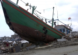 large boat sits among the rubble in Banda Aceh