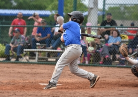 little league baseball player swings bat