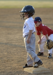 little league player standing on base