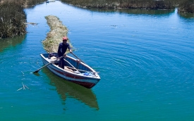 man in small row boat on lake titicaca