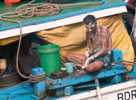 man washing himself on boat near gatway of india photo