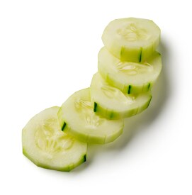peeled cucumber rounds on white background