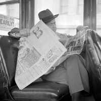 Reading war news while riding on streetcar in San Francisco 1941