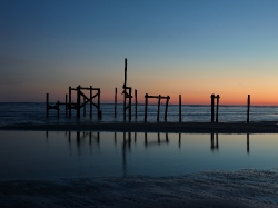 Remnants of an old fishing pier at dusk along the Gulf of Mexico