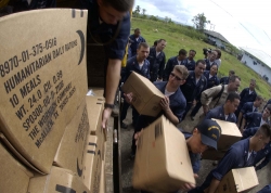 sailors unload trucks full of humanitarian relief supplies