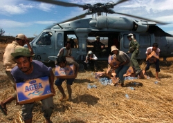 Tsunami victims grab relief supplies from helicopter
