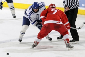 two hockey players fighting for puck