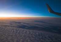 view of stratocumulus clouds sun rising from commercial aircraft