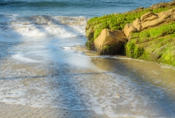 waves-with-green-algae-covered-coastal-rock