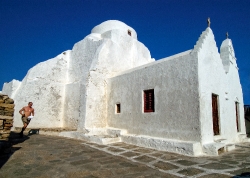 white church along coast in myconos greece