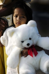 young Indonesian girl clasps her new teddy bear