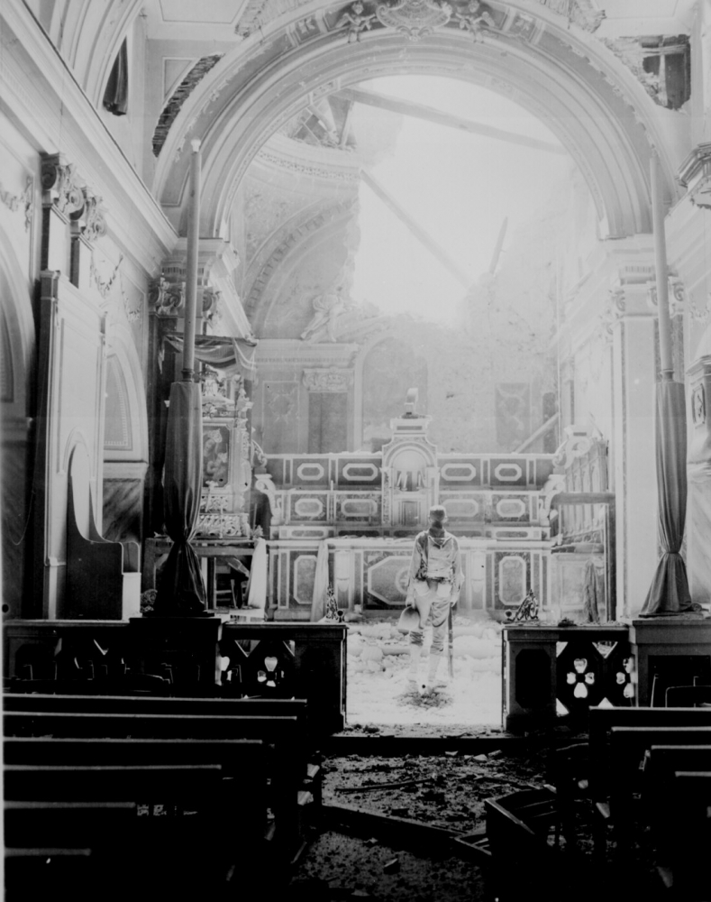  Infantry standing in reverence before an altar in a damaged Catholic Church