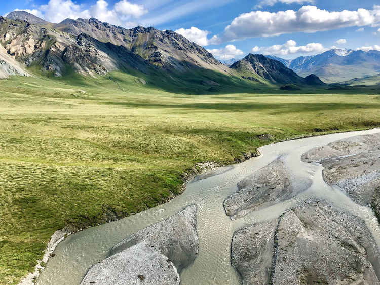 blue sky with clouds streams of the Hullahula river in Alaska