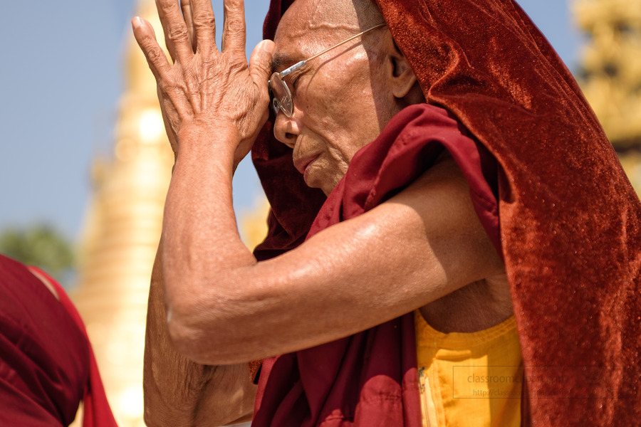 buddhist monk praying at shwedagon pagoda yangon myanmar