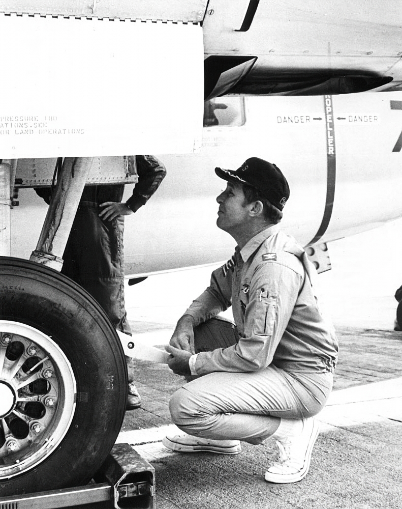 Commander Schirra ,kneels on flight deck of the USS Essex