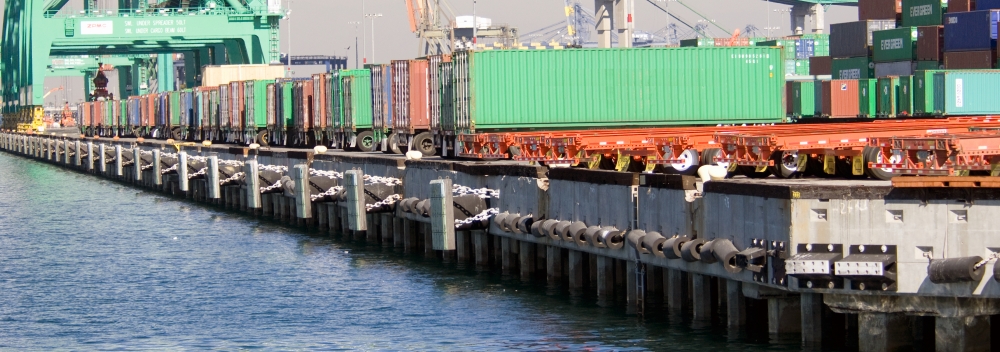 containers lined up along wharf in harbor
