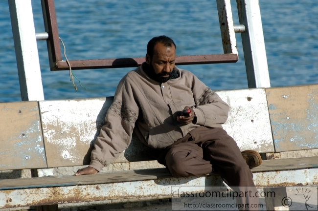 egyptian man sitting at harbor near citadel alexandria egypt 528