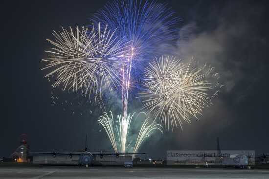 Fireworks explode behind a C-130J Super Hercules