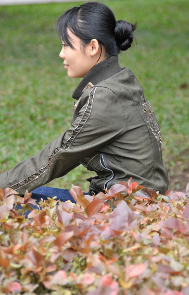 girl sitting on grass near lake in hanoi